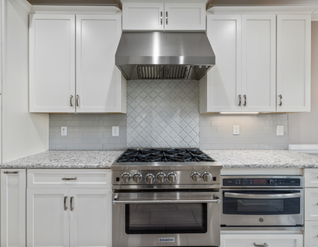 Modern kitchen with stainless steel appliances and white cabinets.