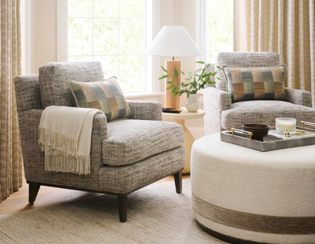 Living room with two armchairs, a ottoman, and decorative items.