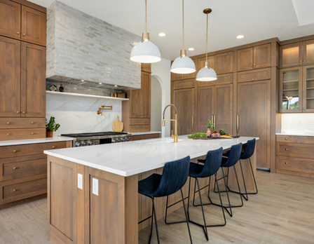 Modern kitchen with wooden cabinets, white countertops, and blue chairs.
