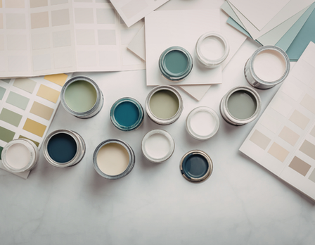 Assorted paint cans and color swatches on a light surface