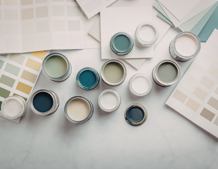 Assorted paint cans and color swatches on a light surface