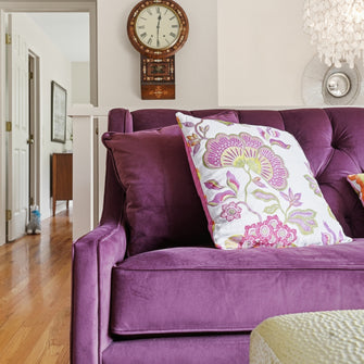 Purple sofa with decorative pillows in a living room setting